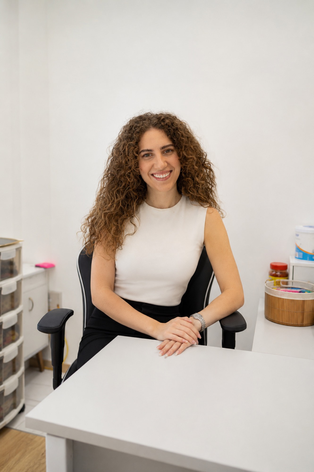 ג'ונא סכראן יושבת ליד שולחן העבודה בחדר הטיפולים